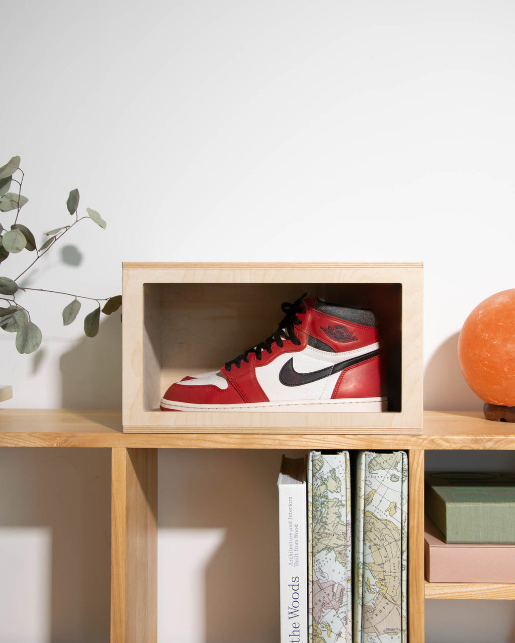 Wooden sneaker display box in natural colorway with clear acrylic front, showcasing a pair of sneakers