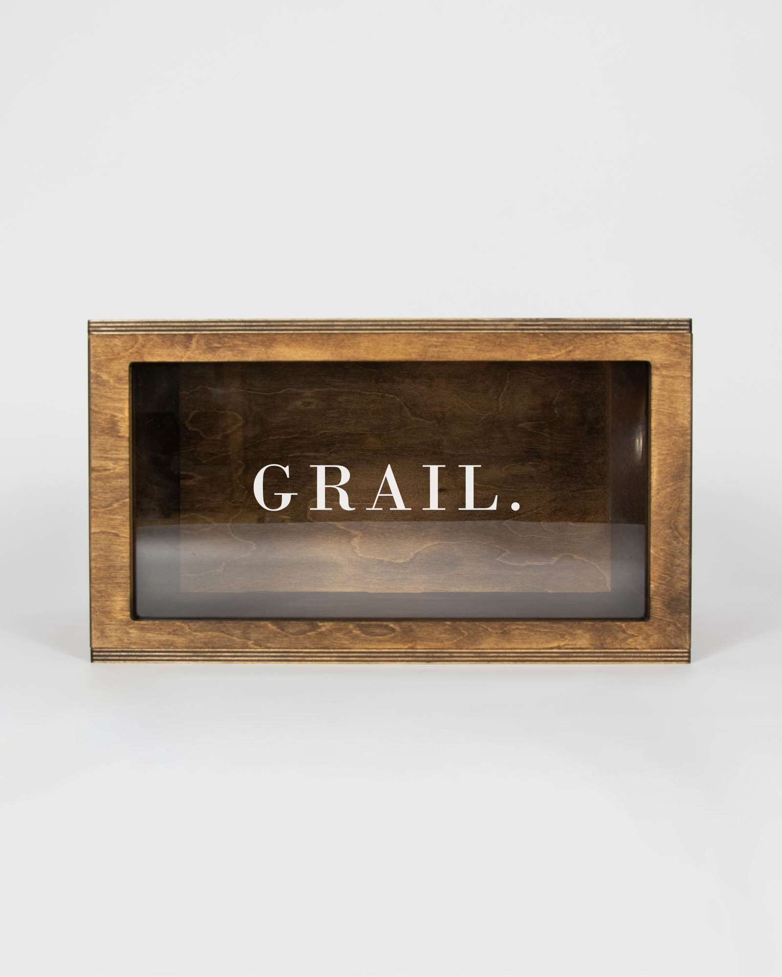 Detailed view of the engraved GRAIL lettering on the plexiglass sneaker box front